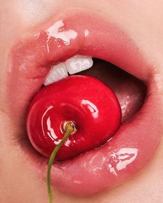 a woman's tongue with a piece of fruit in it