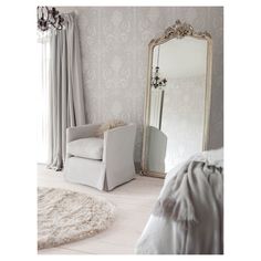 a white chair sitting in front of a large mirror