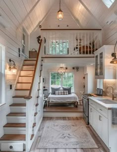 the interior of a tiny house with stairs leading up to the loft and kitchen area