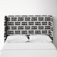 an upholstered headboard with black and white dots