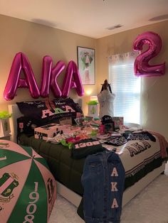 a bedroom decorated with pink and green balloons that spell out the name ava, two