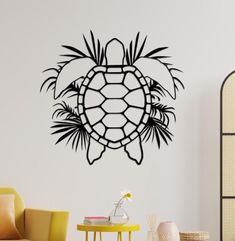 a black turtle wall decal on a white wall next to a yellow chair and table