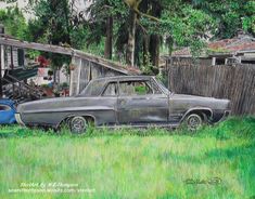 an old car parked in the grass next to a blue pickup truck and some houses