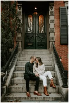 an engaged couple sitting on the steps of their home