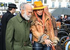 an older man and woman walking down the street