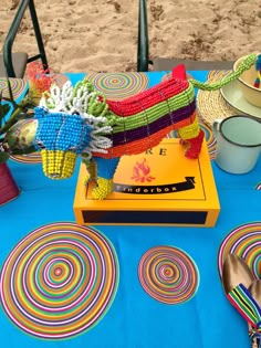 a blue table topped with plates and bowls filled with colorful decorations on top of it