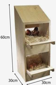 a wooden birdhouse with two birds inside it and hay in the bottom shelf below