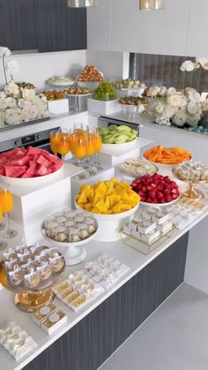 an assortment of desserts and snacks on a buffet table with flowers in the background