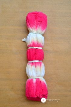 three skeins of pink and white yarn on a wooden table with text overlay