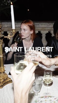 two women sitting at a table with wine glasses in front of them and the caption saint laurent paleno summer nights