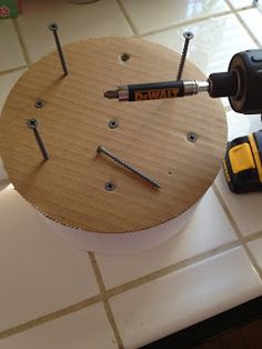 a drill and screwdriver sitting on top of a wooden clock with holes in it