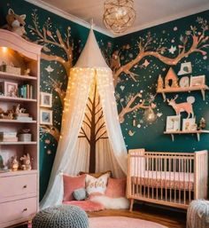 a baby's room decorated in pink and green with trees on the wall, lights strung from above