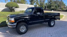 a black pickup truck parked in front of a house