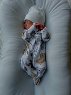 a newborn baby wrapped in a blanket is laying on a pillow