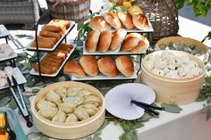 a table topped with lots of different types of food on plates and serving trays