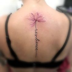 a woman's back with a flower tattoo on it