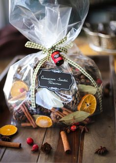 a bag filled with cinnamon, orange slices and spices on top of a wooden table