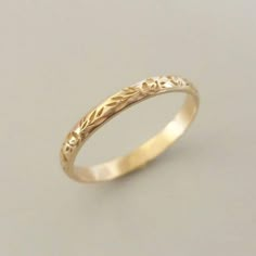 a gold wedding ring with leaves on it