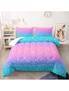 a bed with pink and blue bedspread in a room