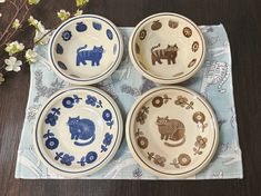 four blue and white plates with animals on them