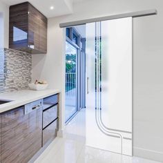 a modern kitchen with sliding glass doors leading to the outside patio and outdoor deck area