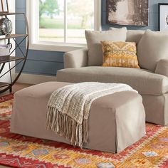 a living room with blue walls and a large ottoman in front of the couches