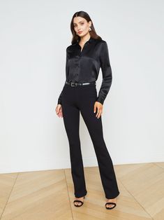 A quintessential blouse in a lustrous silk charmeuse and true black hue. Classic look has a soft, liquid hand and tailored silhouette shaped by sharp sartorial details like a stand collar, long button-cuff sleeves, and back yoke with inverted pleat. An open neckline and curved hem add subtle femininity. A nimble style that works equally well with jeans or skirts. Fastens in front with tonal buttons. | L'AGENCE Tyler Silk Blouse Top In Black Chic Silk Business Blouse, Chic Silk Blouse For Business, Tailored Elegant Blouse For Business, Sleek Solid Silk Blouse, Timeless Fitted Business Blouse, Elegant Satin Blouse For Workwear, Sleek Silk Blouse For Business, Silk Business Blouse For Fall, Luxury Fitted Blouse For Evening