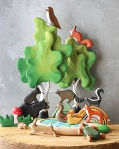 a wooden table topped with figurines of animals and trees