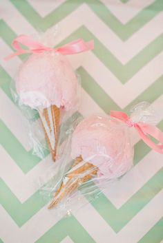 two ice cream cones wrapped in plastic and sitting on top of a chevron table