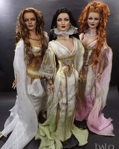 three dolls are dressed in white and pink