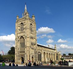 people are sitting on benches in front of an old building