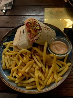 a plate with french fries and a wrap on it