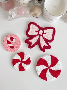 three crocheted coasters are sitting on a table with candy canes and other items