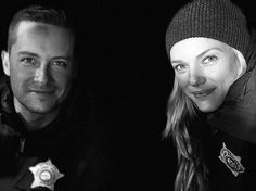 black and white photo of man and woman with police badge on their hat looking at the camera