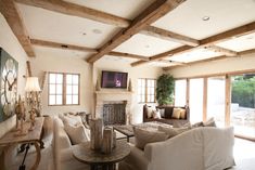 a living room filled with furniture and a flat screen tv mounted on the wall above a fireplace