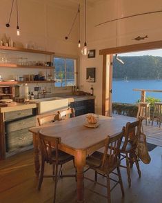 an open kitchen and dining room area overlooking the water