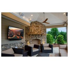 an outdoor living area with furniture and a flat screen tv mounted on the wall above it