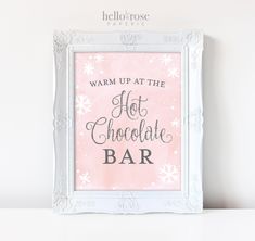 a pink and white framed sign that says warm up at the hot chocolate bar