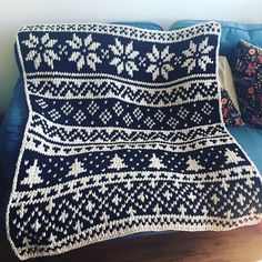 a blue couch with a white knitted blanket on it