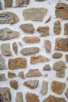 an old stone wall with some rocks on it's side and one rock in the middle