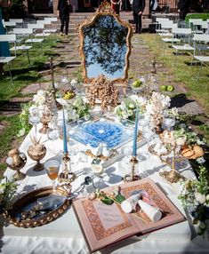 an elaborately decorated table is set up for a wedding ceremony with candles and flowers