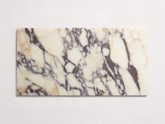 a white and brown marble textured tile on a wall