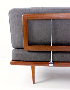 the back end of a couch with a wooden frame and metal bar attached to it