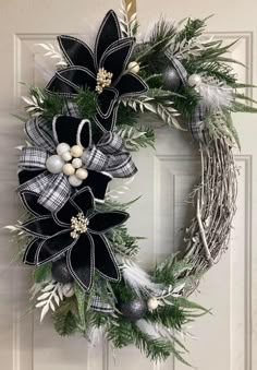 a black and white christmas wreath hanging on a door