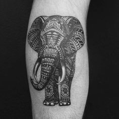 an elephant tattoo on the left arm with intricate patterns and details in black and white