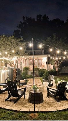 an outdoor patio with lights and lawn chairs in the middle of the yard at night