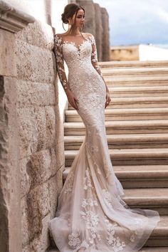 a woman in a wedding dress standing on some steps