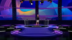 a woman is standing on stage in front of two large screens with lights and microphones