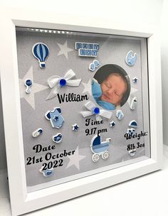 a baby's birth photo in a white frame with blue stars and hot air balloons