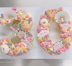 two donuts shaped like the number three with unicorns and rainbows on them